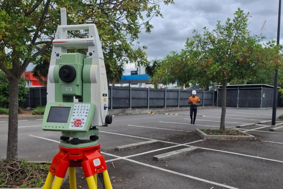 A total station on a tripod in a car park ready for practical training