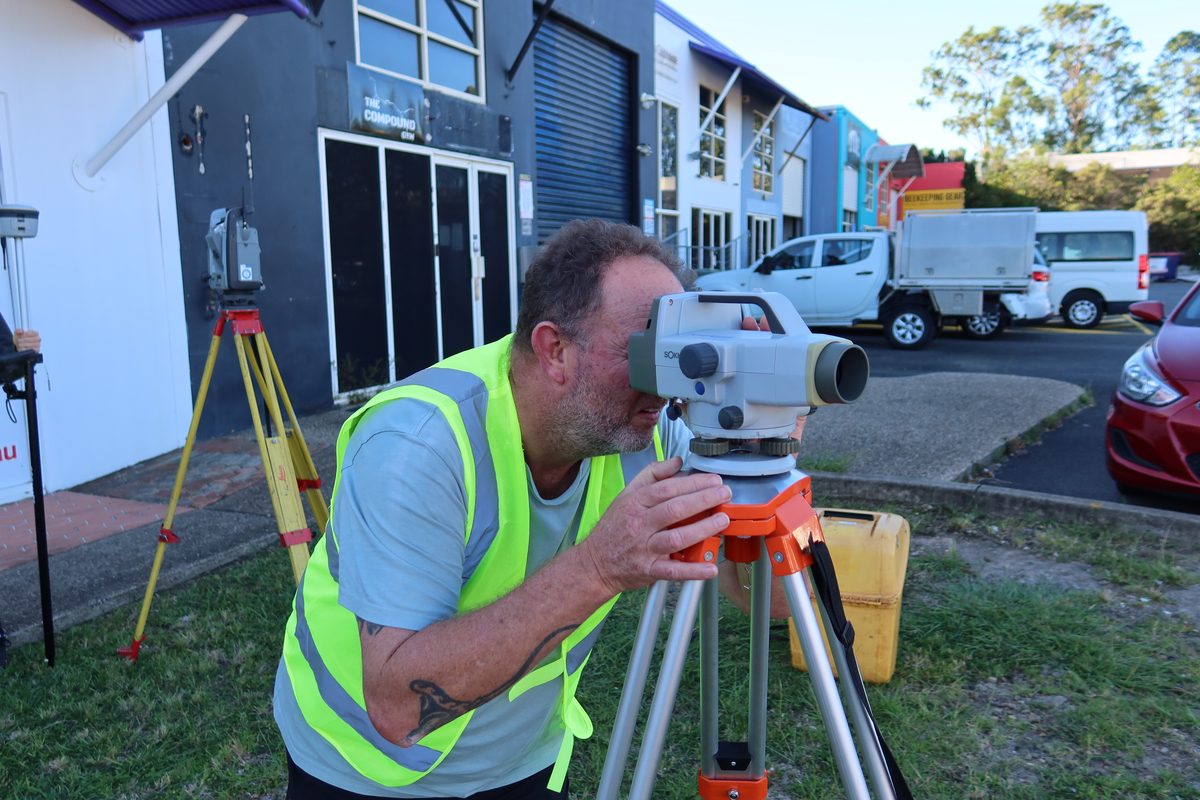 A student reading an automatic level mounted on a tripod