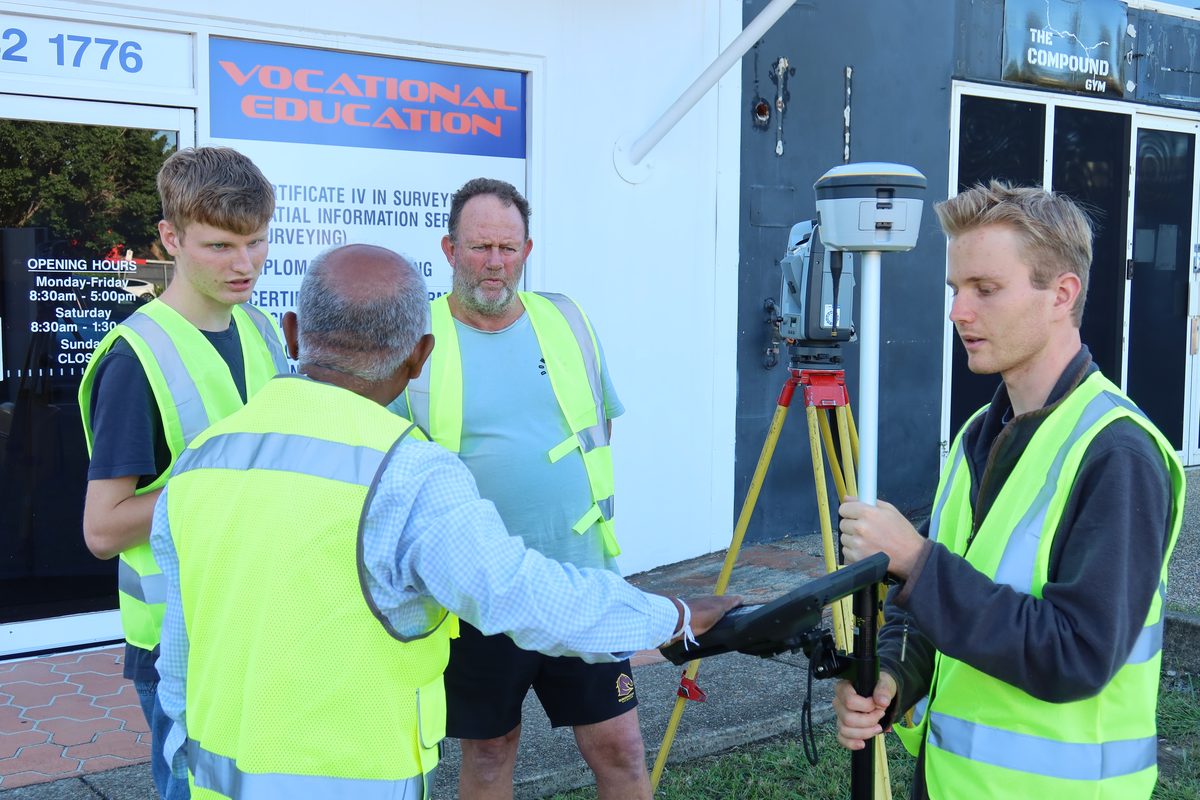 Students discussing GNSS and total station fieldwork outside the SRDITA building