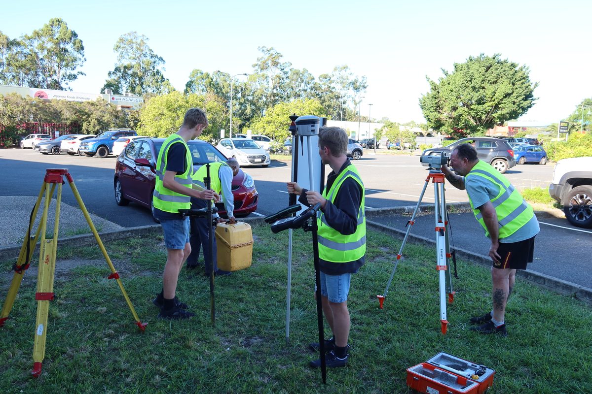 Students setting up GNSS and total station equipment during a fieldwork session